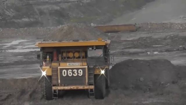 Тяжелые самосвалы в действии: Komatsu HD785 и Caterpillar 777 выгружают мусор на свалке