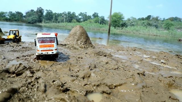 Джип и тракторы в грязи на берегу реки