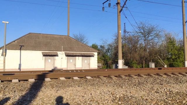 Железнодорожный переезд на котором есть шлагбаум и барьер. Железная дорога. Грузовой поезд. Дрезина