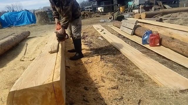 Распускаю  бревно бензопилой на доски