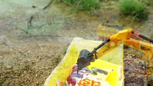 Экскаватор грузит пакетики в грузовик и карьерный самосвал