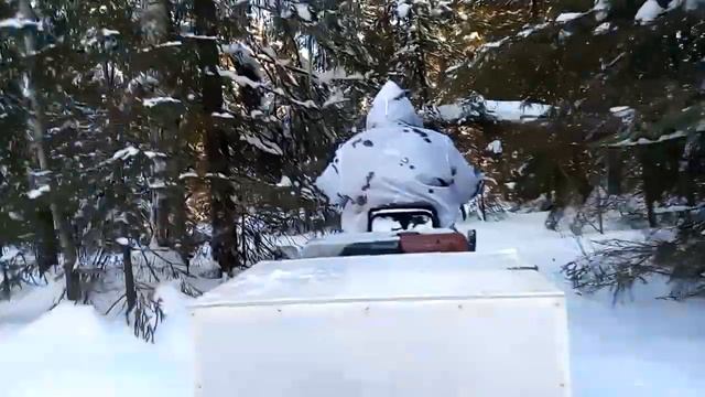 Мототолкач по глубокому снегу везёт двоих.