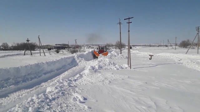 Кировец чистит снег в деревне