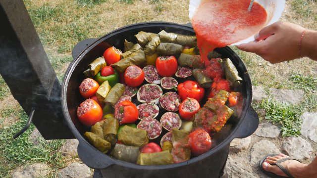 Долма или фаршированные овощи в казане на костре.