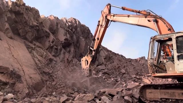 Разрушение скалы с помощью экскаватора.