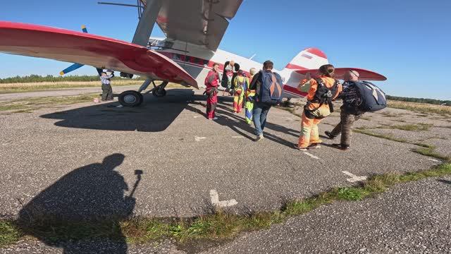 Группа тандем-инструкторов и их пассажиров движется к салону самолета АН-2. Флай Питер