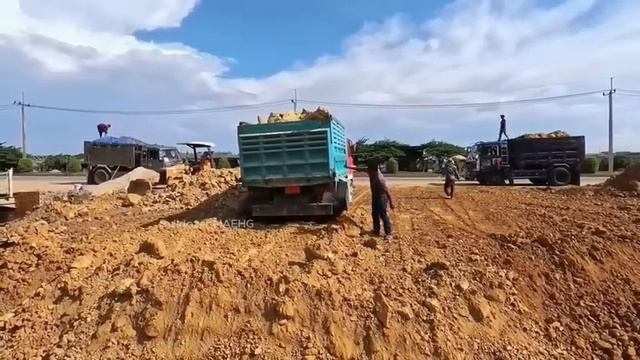 Бульдозер и Экскаватор засыпают бетонную дренажную систему.