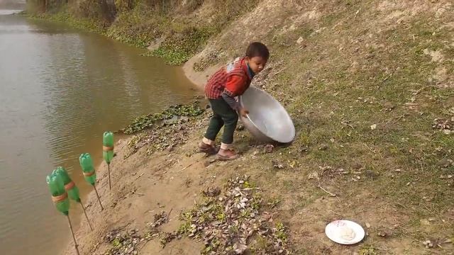 Мальчуган ловит большую рыбу , на примитивную снасть.
