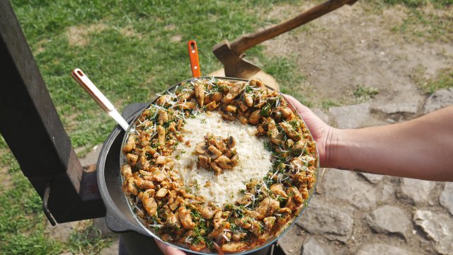 Ризотто с курицей и грибами в казане на костре.