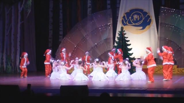 танец Санта Клаусов и снежинок на сцене