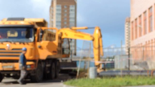 Желтый Экскаватор нагружает землёй Желтый Самосвал