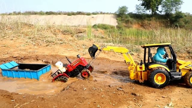 Экскаватор JCB вытаскивает трактор из ямы