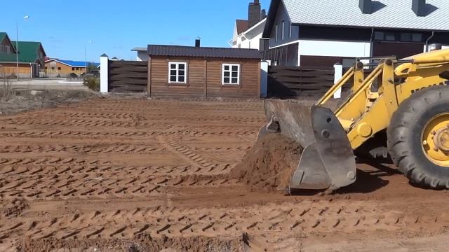 Планировка участка экскаватором-погрузчиком.