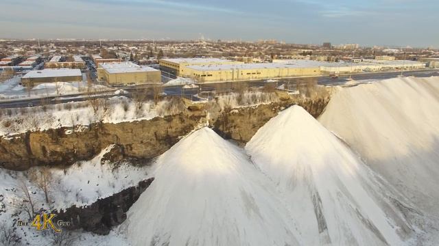 Грузовики разгружают снег в каньон. Канада