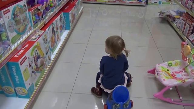 Катаемся на машинках в магазине игрушек.